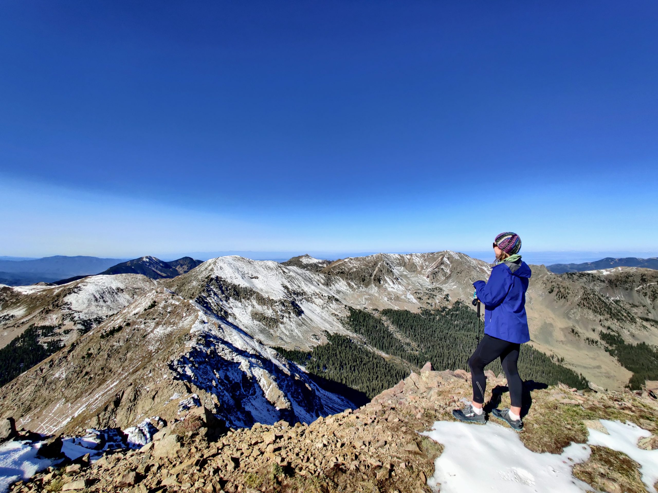 Woman on a mountain top after taking a custom charter with Shuttle Taos.